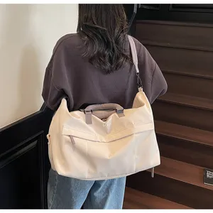 Detailed view of the large capacity beige travel duffel bag with shoulder strap and handles.