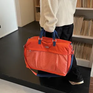 Large capacity travel duffel bag detail, orange design with front grid pocket and handy straps.