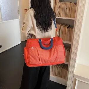 Large capacity travel duffel bag, casual orange hand shoulder bag with front pocket design.