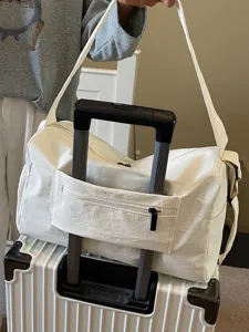 Sac de voyage blanc avec sangle pour valise et bandoulière pour courts séjours et sport.