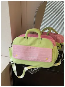 Detailed close up view of the color block travel duffel bag showcasing front pocket and handles.