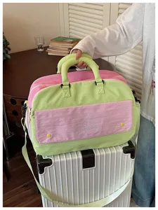 Color-blocking travel duffel bag detail, pink and green lightweight large capacity design.
