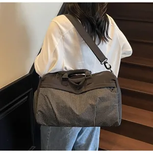 Grand sac de voyage cabine détail, motif à carreaux noirs, bandoulière et poignée.