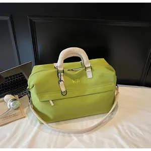 Detailed close-up of a large capacity green travel duffel bag with white straps and sleek design.