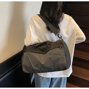 Grand sac de voyage étanche avec motif à carreaux pour le sport et les déplacements.