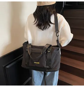 Detalle de la bolsa de viaje negra que muestra el tejido resistente y las asas fuertes.