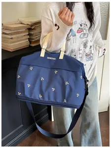 Grote capaciteit geborduurde reistas duffel tas met handvatten en schouderriem voor reizen.