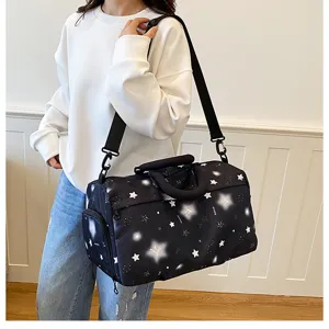 Detailed view of the large capacity black star print travel duffel bag with shoulder strap.
