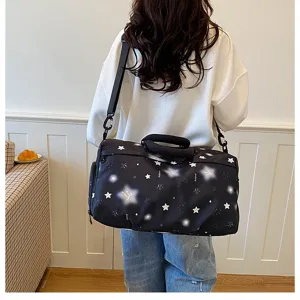 Detail view of large capacity black travel duffel bag with star print and comfortable straps.