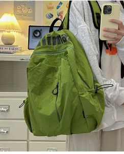 Detail of lightweight waterproof green backpack, showing large capacity and pockets.