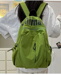 Green nylon waterproof backpack detail view, casual outdoor travel gear with front pocket.