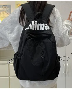 Black casual nylon backpack detail view, featuring front zipper pocket and spacious design.