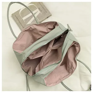 Detailed view of a stylish color-block tote bag with large capacity, green and pink design.