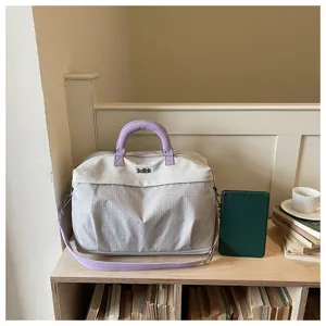 Dettaglio borsa da viaggio capiente con design grigio chiaro viola e tessuto resistente.