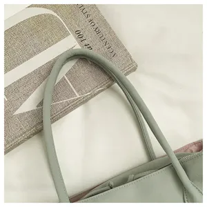 Detailed close-up view of the light green tote bag strap and textured fabric surface.