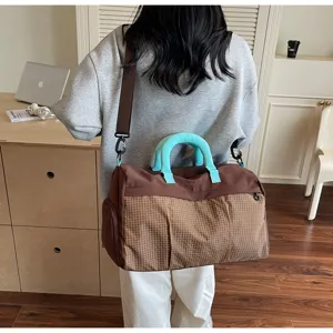 Vue détaillée du grand sac de voyage avec motif à carreaux élégant et poignées colorées.
