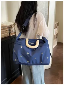 Detailopname van de grote blauwe reistas met mooie schattige strik borduursels.