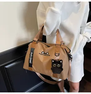 Sac de voyage marron élégant avec joli pendentif chat, bandoulière et grand rangement.