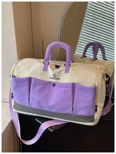 Large capacity travel duffle bag detail showcasing multiple purple pockets and durable zippers.