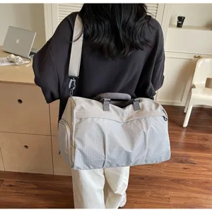 Vue detaillee du grand sac de voyage avec tissu imperceptible et bandouliere ajustable.