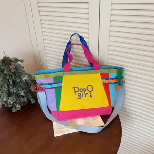 Detailed view of colorful color-block canvas tote bag with sturdy handles and shoulder strap.