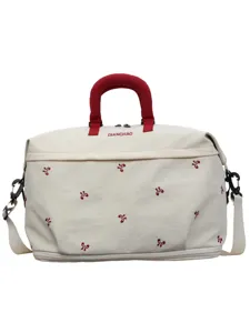 Grote canvas reistas weekend tas met rode handgrepen en schattige geborduurde bloemdetails.