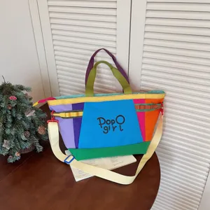 Colorful canvas tote bag detail, patchwork design with shoulder strap and front graphic.