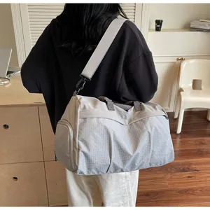 Vue détaillée d'un grand sac de voyage avec motif à grille et sangle confortable.