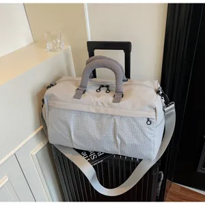 Détail de grand sac de voyage polochon, sac de sport gris clair imperméable avec bandoulière.
