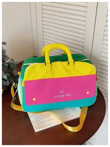 Detailed view of color-blocked travel duffel bag, spacious canvas gym bag with vibrant panels.