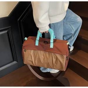 Detailed view of large capacity travel duffel bag with stylish color block design and straps.