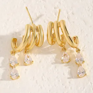 Close-up of gold multi-layer C-hoop earrings with elegant pear-shaped clear rhinestones