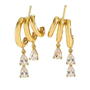 Detailed view of gold multi-layered C-hoop earrings with elegant pear-shaped zirconia
