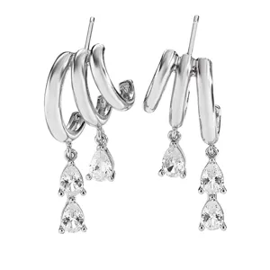 Close-up detail of silver triple-hoop tassel earrings with pear-cut cubic zirconia.