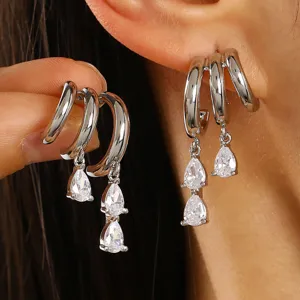 Detailed view of stacked silver hoop earrings with dripping pear-cut zircon stones
