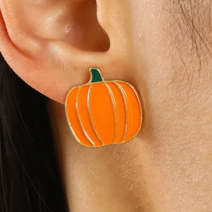 Primer plano de una modelo luciendo un pendiente de tuerca de calabaza naranja.