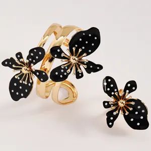 Detailansicht von Vintage-Armreif und Ring mit schwarzen Blumen und weißen Punkten.