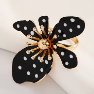 Detailansicht eines Retro-Blumenrings mit schwarzer Emaille und weißen Punkten im Design