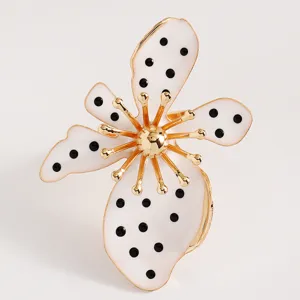 Detailansicht eines Vintage-Blumenrings mit weißen Emaille-Blütenblättern und schwarzen Punkten.