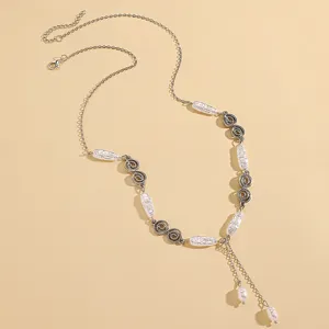 Detail of vintage style chain necklace with white pearl pendants and metal charms