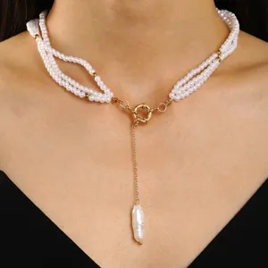 Close-up of vintage multi-strand pearl necklace with gold OT toggle clasp and pearl pendant.