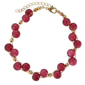 Macro detail of a vintage red beaded bracelet featuring gold spacer beads and extender chain