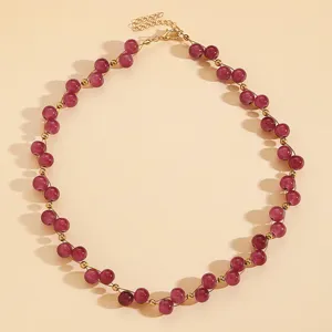 Detailed macro view of vintage-style red beaded necklace with elegant gold spacer beads