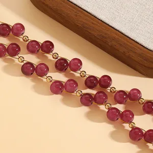 Close-up of vintage red round beads with gold spacer accents on a minimalist necklace.