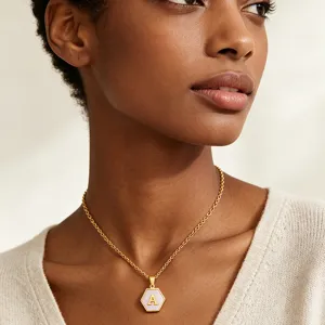Gold stainless steel hexagonal pink shell initial necklace on female model