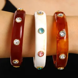 Detailed macro view of vintage resin cuff bangles inlaid with colorful rhinestones