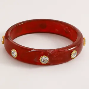 Macro detail view of retro red marble acrylic bangle with sparkling rhinestone inlay