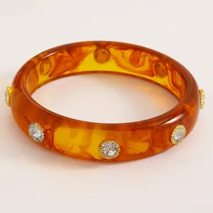 Detailed view of vintage amber acrylic bangle embellished with sparkling rhinestones