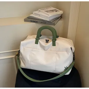 Large capacity travel duffel bag with green handles, stylish weekender bag for trip.