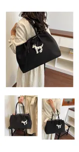 Detailed view of large capacity black tote bag with cute spotted dog charm for commuting